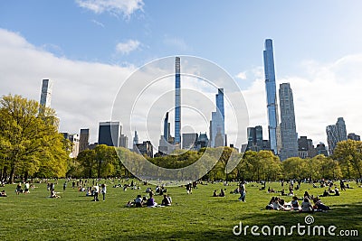Sheep Meadow with People and the Midtown Manhattan Skyline at Central Park during Spring in New York City Editorial Stock Photo