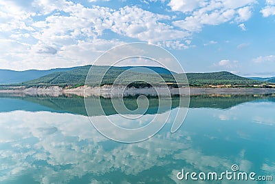 Beautiful landscape with turquoise lake, reflection of blue sky and wild mountains. Relaxing paradise background. Tranquility. Stock Photo