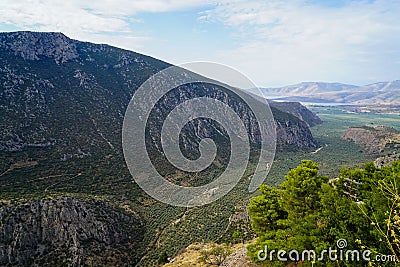 Beautiful landscape view of Parnassus mountain slope valley, green olive groves through Ionian sea with bright blue sky background Stock Photo