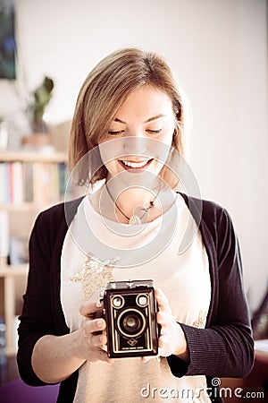 Beautiful laughing girl with a vintage film camera Stock Photo