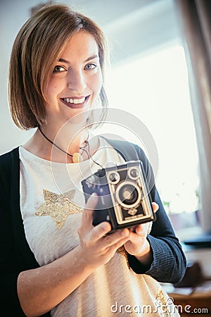 Beautiful laughing girl with a vintage film camera Stock Photo
