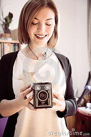 Beautiful laughing girl with a vintage film camera Stock Photo