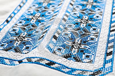 Beautiful light blue Ukrainian national embroidery on white fabric, closeup Stock Photo