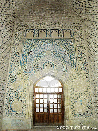 Beautiful light radiation from a large wooden door window and ancient colored tiles on the interior walls of the Soltanieh Dome. Editorial Stock Photo