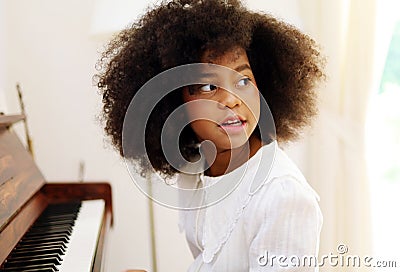 African American girl smile happy playing and learning piano classroom in holiday weekend at home. Stock Photo