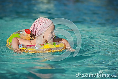 Beautiful Little cheerful girl swimming in the pool Stock Photo