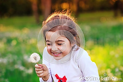 Beautiful little child with dandelion flower in sunny summer par Stock Photo