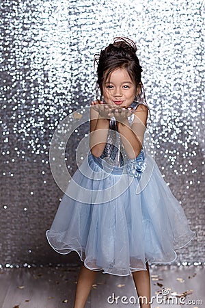 Beautiful little child girl in silver and blue dress with confetti Stock Photo