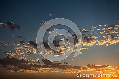 Beautiful little clouds illuminated by the sunset sun. Golden Hour Sky during the fall of the sun Stock Photo