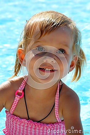 Beautiful little girl with blue eyes against the background of the pool. Stock Photo
