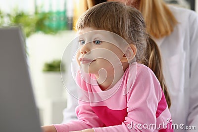 Beautiful little girl child carefully looks at monitor screen Stock Photo