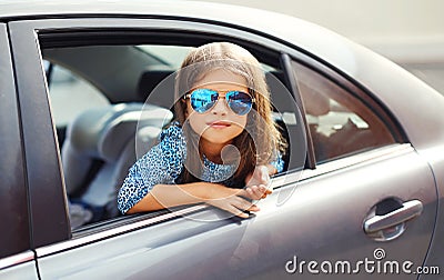 Beautiful little girl child sitting in car, looking out window Stock Photo