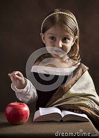 Beautiful little girl Christian, dressed in old clothes, reading the Bible, the hand gestures highlights words and main ideas Stock Photo