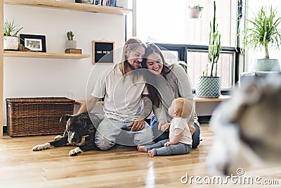 Beautiful little girl and her parent getting some puppy love on the living room Stock Photo