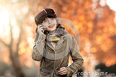 Beautiful little girl hold mobile phone and gladness talk Stock Photo