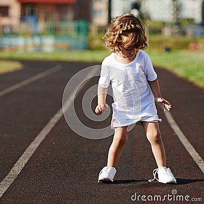 Beautiful little girl learning to tie shoelaces Stock Photo