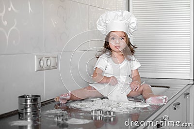 Beautiful little girl learns to cook a meal in the kitchen Stock Photo