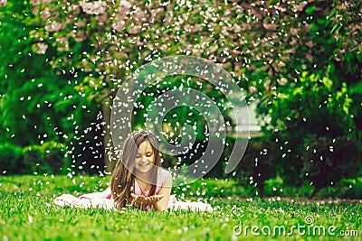 Little girl on green grass with petals Stock Photo