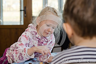 Beautiful little girl playing a game of checkers Stock Photo