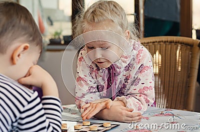 Beautiful little girl playing a game of checkers Stock Photo