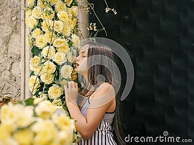 Beautiful little girl smell flowers in garden Stock Photo