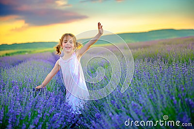 Beautiful little girl is walking and having fun on the lavender field Stock Photo