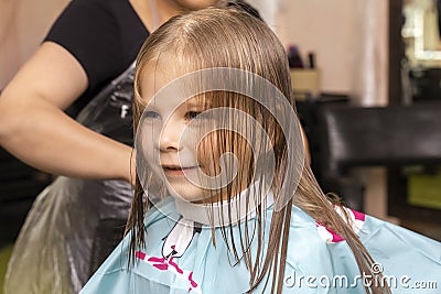 Beautiful little red-haired girl at the barber shop Stock Photo