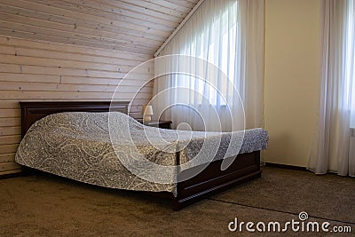 Beautiful loft bedroom with bed near woodern wall Stock Photo