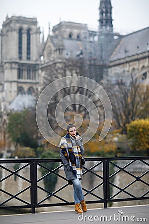 Beautiful lonely brunette girl in Paris, standing alone in a gray coat Stock Photo