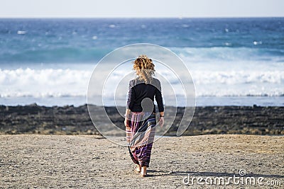 Beautiful lonely caucasian middle age woman walk and enjoy the nobody beach in season. freedom and alternative lifestyle concept Stock Photo