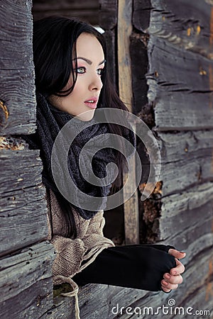 Beautiful lonely girl looks out the window of the house in a winter clear frosty winter day Stock Photo