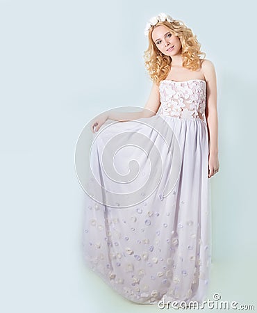 Beautiful lovely gentle elegant young blond woman in a white sundress chiffon and curls, and a wreath of flowers in her hair Stock Photo