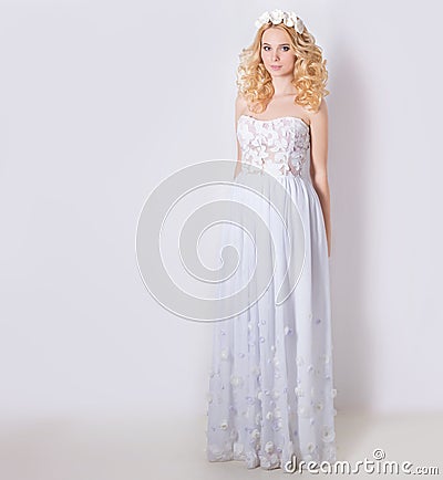 Beautiful lovely gentle elegant young blond woman in a white sundress chiffon and curls, and a wreath of flowers in her hair Stock Photo