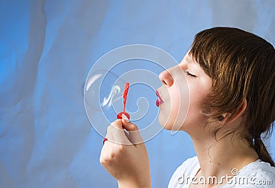 Beautiful, lovely girl blows soap bubbles Stock Photo