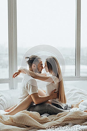 Beautiful loving couple kissing in bed Stock Photo