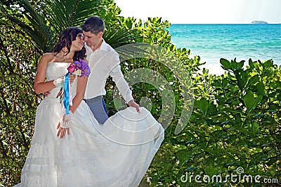 Beautiful loving couple of newlyweds are stand on the beach. Wedding and honeymoon in the tropic on the island of Sri Lanka. Stock Photo