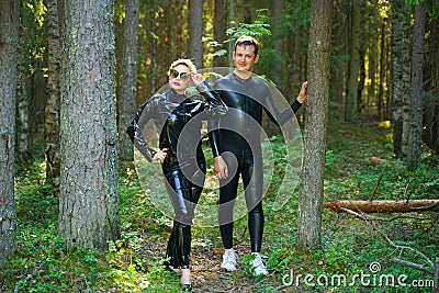 Beautiful loving couple posing in latex rubber costumes Stock Photo