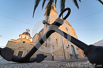 Beautiful low angle shot of a church with an anchor statue in front of it under the tree Altea Spain Stock Photo
