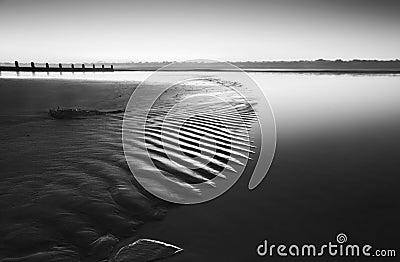 Beautiful low tide beach vibrant sunrise in black and white Stock Photo