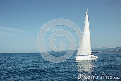 Yacht with white sails on the calm sea in good sunny day. Stock Photo