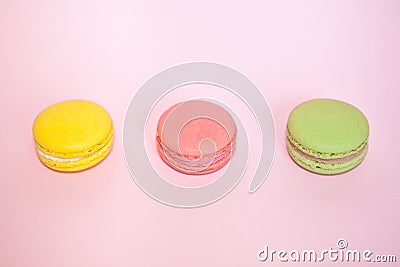 Beautiful macaroons on pastel pink background - raspberry, mint and lemon cakes Stock Photo