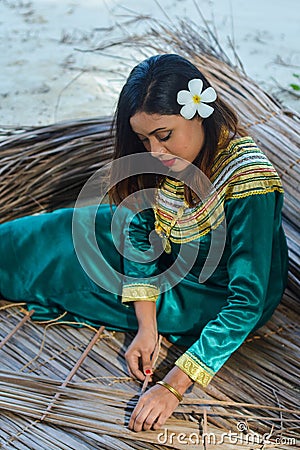 Beautiful maldivian lady in national dress making sheets for roof Editorial Stock Photo