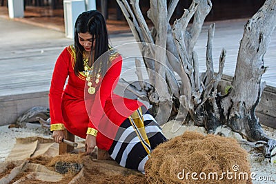 Beautiful maldivian woman in national dress making ropes Editorial Stock Photo