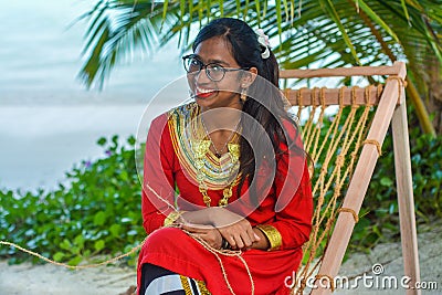 Beautiful maldivian woman in national dress smiling while crafting ropes Editorial Stock Photo