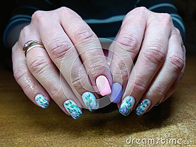 The manicurist excellently made her work a beautiful manicure with a polish gel on her hands and the client is happy Stock Photo