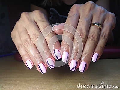 The manicurist excellently made her work a beautiful manicure with a polish gel on her hands and the client is happy Stock Photo