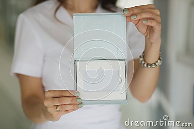 Beautiful medical worker hold gift certificate. Cosmetologist Stock Photo