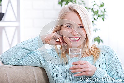 Beautiful middle aged woman drinking water in the morning Stock Photo