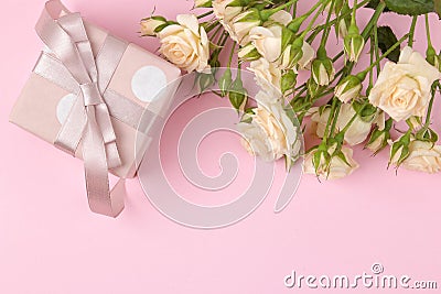 Beautiful mini roses with a pink gift box on a bright pink background. holidays. Valentine`s Day. women`s Day. top view. space f Stock Photo