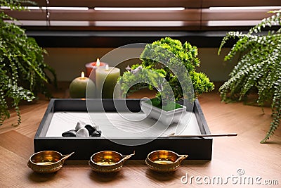 Beautiful miniature zen garden, candles and oil lamps near window Stock Photo